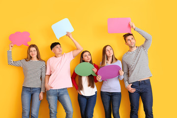 Group of young people with blank speech bubbles on color background