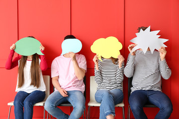 Naklejka premium Group of young people with blank speech bubbles on color background