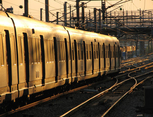 Fototapeta premium Passenger train moving slowly in sunset light