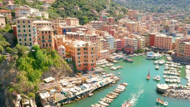 Aerial view of Camogli harbor. Colorful buildings near the ligurian sea beach, Italy. View from above on boats and yachts moored in marina with green blue water.