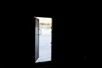 picture of view from dark warehouse through open door on  snow