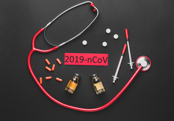 Stethoscope and medicines for Coronavirus on dark background