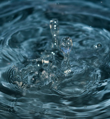 Conceptual image for water purity. Blue water splash​ed for background. Drops and waves in a glass.