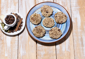vegan cookies on blue plate and cup bith coffee beans and spices  on wooden background