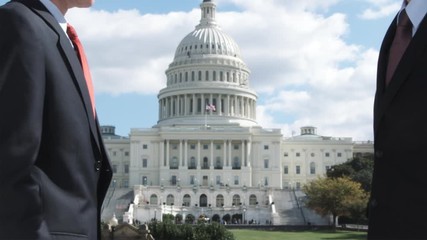 SLO MO, MS of two well-dressed men shaking hands in front of the Capitol Building, Washington DC