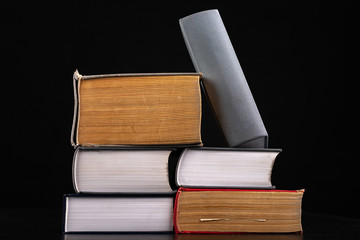 A pile of very thick and voluminous books. Enormous amount of knowledge in stacked books.