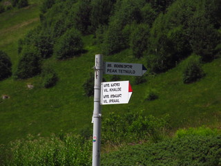 Mountain landscape of Svaneti on bright summer sunny day. Mountain lake, hills covered green grass on snowy rocky mountains background. Caucasus peaks in Georgia. Amazing view on wild georgian nature