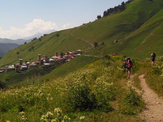 Mountain landscape of Svaneti on bright summer sunny day. Mountain lake, hills covered green grass on snowy rocky mountains background. Caucasus peaks in Georgia. Amazing view on wild georgian nature