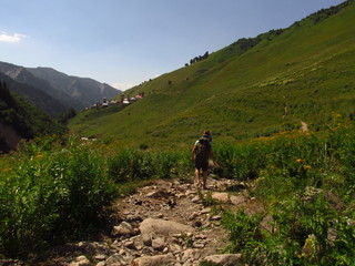 Fototapeta premium Mountain landscape of Svaneti on bright summer sunny day. Mountain lake, hills covered green grass on snowy rocky mountains background. Caucasus peaks in Georgia. Amazing view on wild georgian nature