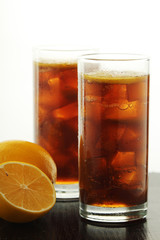 Glasses with cuba libre cocktail or cola with ice or cold tea with lemon	