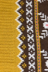 close up knitted warm winter product. skandinavian pattern, brown, white, ocher