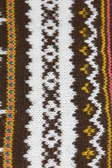 close up knitted warm winter product. skandinavian pattern, brown, white, ocher