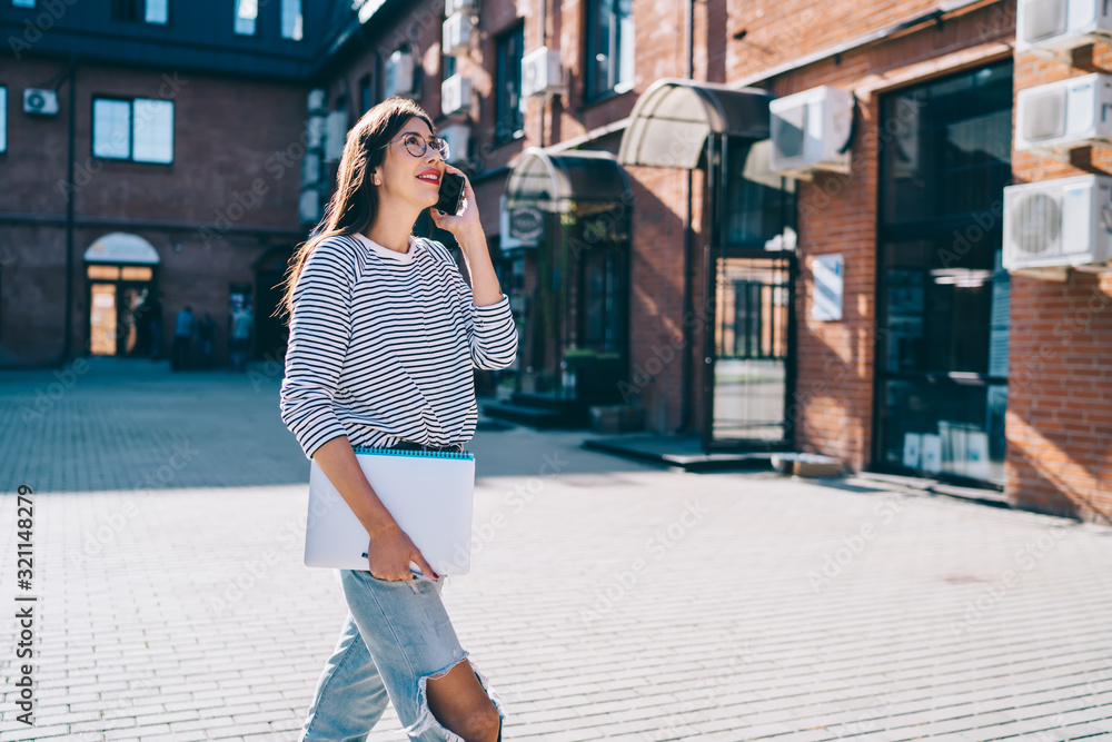 Poster positive hipster girl in casual apparel looking up while going to university presentation with knowl