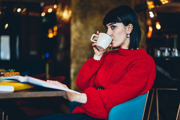 Female drinking coffee in cafe during work