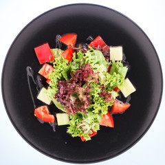 The salad of the robe on a black plate