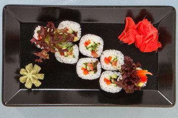 Sushi on a black plate. White background