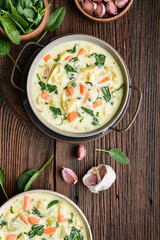 Creamy Tortellini pasta soup with spinach, celery, carrot and chicken broth