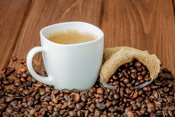 Coffee cup with coffee bag on wooden table. View from top