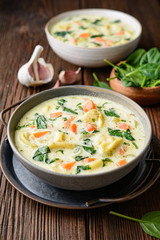 Creamy Tortellini pasta soup with spinach, celery, carrot and chicken broth
