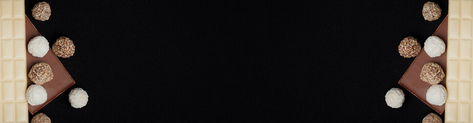 Stack of Black and White Chocolate isolated on black background, op view with copyspace for your text