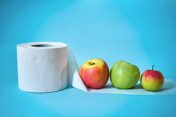 Fruits and toilet roll on a blue background. Healthy eating concept.