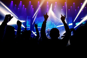 Man with raised hands enjoys a music show