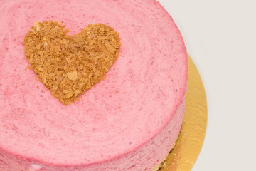 Cake for lovers on Valentine's day close-up on a white background, heart made of waffle crumbs on a pink mousse