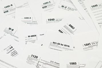 Many tax form blanks lies on table close up. Tax payers paperwork routine and bureaucracy concept