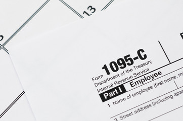 IRS Form 1095-C Employer-Provided Health Insurance Offer and Coverage tax blank lies on empty...