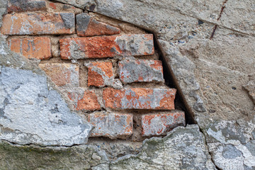 brick wall with the rest of the plaster on an old building with a distinctive structure