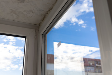 New windows on the terrace unfinished whitewashing and carpentry job on wooden and steel frames with vibrant blue background sky in the city