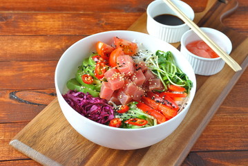 Organic food. Fresh seafood recipe. Tuna poke bowl with crystal noodles, fresh red cabbadge, avocado, cherry tomatoes. Food concept poke bowl on wooden background