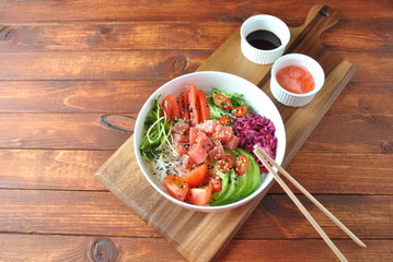 Organic food. Fresh seafood recipe. Tuna poke bowl with crystal noodles, fresh red cabbadge, avocado, cherry tomatoes. Food concept poke bowl on wooden background