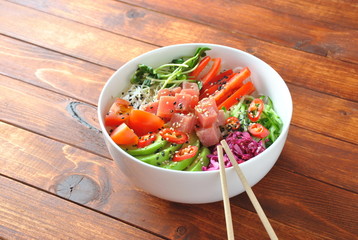 Organic food. Fresh seafood recipe. Tuna poke bowl with crystal noodles, fresh red cabbadge, avocado, cherry tomatoes. Food concept poke bowl on wooden background