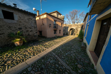 Fototapeta premium Sunset view at a medieval age town in Extremadura, Spain. A diminishing perspective view of the street and houses of the historical Granadilla town 
