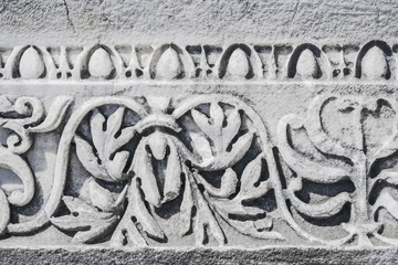 Part of a decorative Ornament on a fragment of a marble structural element of an ancient building. .