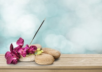 Zen basalt stones and flowers on wooden desk