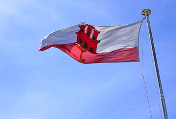The flag of Gibraltar floating on a mast
