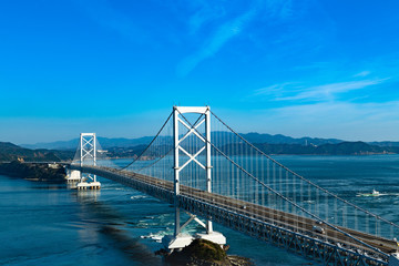 日本　大鳴門橋と渦潮の海峡を通過する船舶