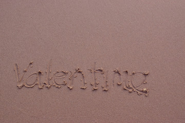  On the sand there is a letter written valentime.
