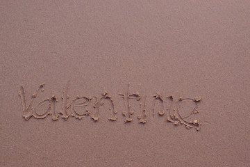  On the sand there is a letter written valentime.