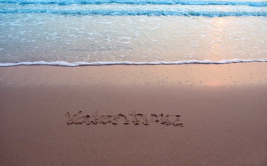  On the sand there is a letter written valentime.