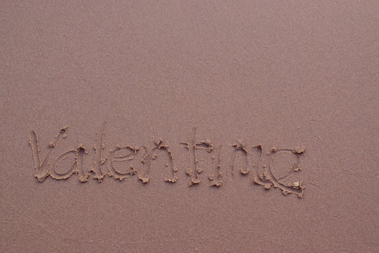  On the sand there is a letter written valentime.