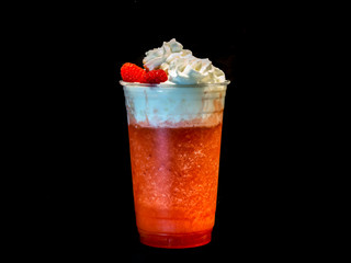 Fresh raspberry smoothie with whipped cream in a clear plastic cup.