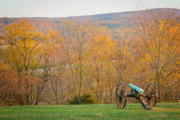 Fototapeta na wymiar Ancient Cannon from the Civil War at the Antietam National Battlefield in Sharpsburg, Maryland, USA with colorful Trees on a Autumn Day