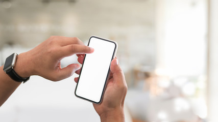 Cropped shot of young male using his blank screen smartphone