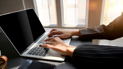 Side view of female typing on laptop in comfortable workplace