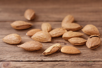 Inshell almonds and peeled kernels are on wooden table