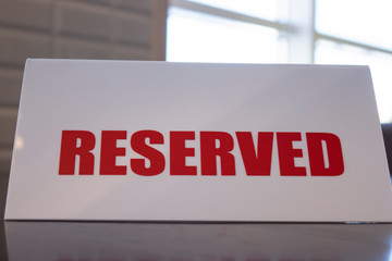 A sign that says reserved on a table in a restaurant or cafe, selective focus.