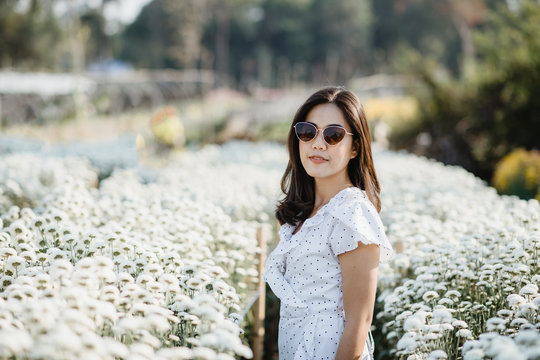 Photos of white women dressed in flowers admiring flowers while walking through the summer chrysanthemum fields.